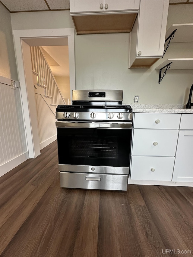 kitchen with stainless steel gas stove, light countertops, white cabinets, and dark wood finished floors