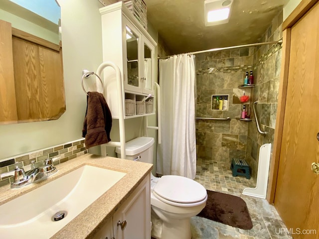 full bathroom with vanity, toilet, decorative backsplash, and tiled shower