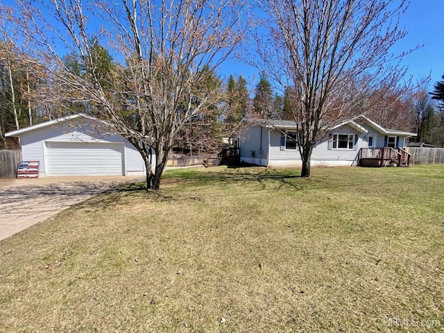 exterior space with concrete driveway, a garage, a front lawn, and fence