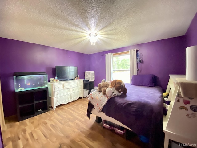 bedroom with light wood-type flooring and a textured ceiling