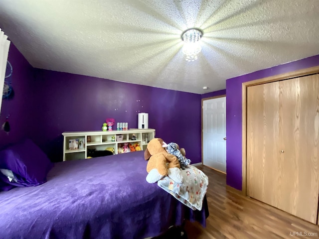 bedroom featuring a textured ceiling, a closet, and wood finished floors