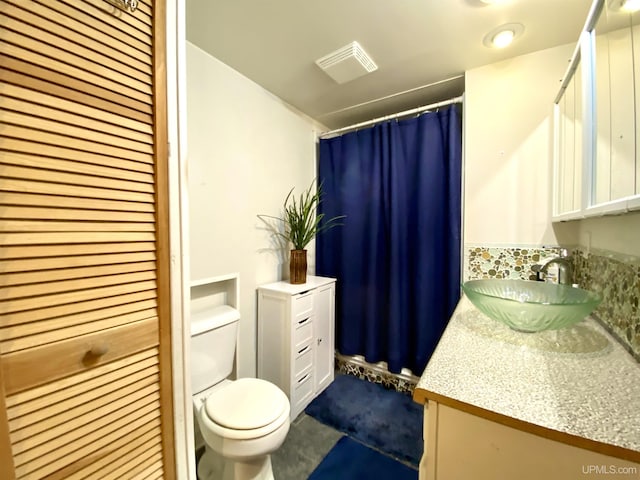 bathroom featuring vanity, toilet, and visible vents