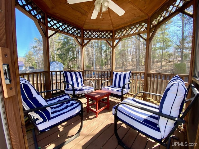 sunroom with ceiling fan and an outdoor living space