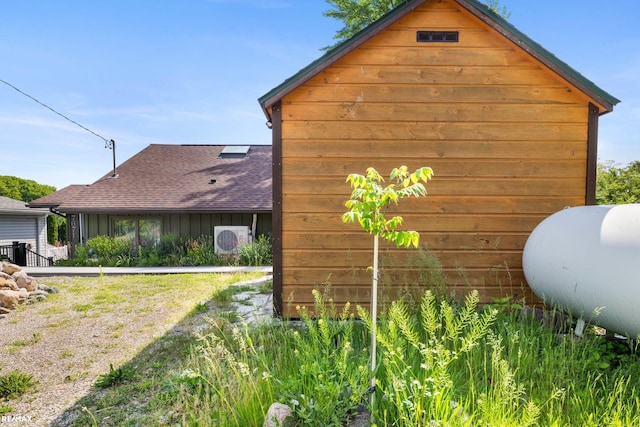 view of side of property with ac unit and roof with shingles