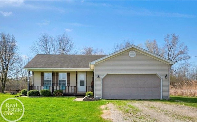 ranch-style house featuring covered porch, an attached garage, a front lawn, and driveway