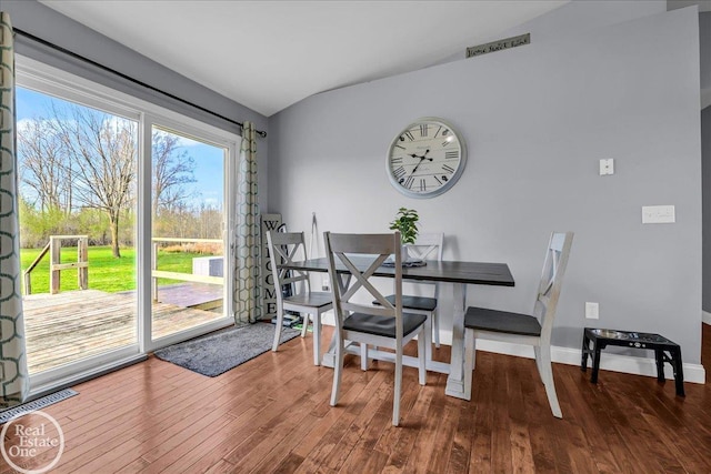 dining area featuring vaulted ceiling, baseboards, visible vents, and wood finished floors