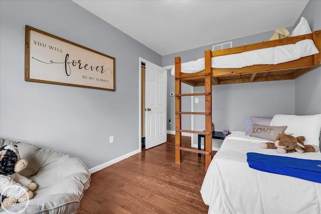 bedroom featuring baseboards, visible vents, and wood finished floors