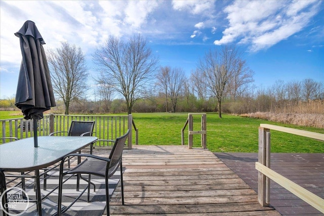 wooden terrace featuring a lawn and outdoor dining space