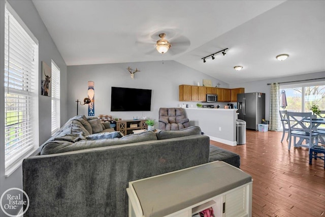 living room featuring wood finished floors, ceiling fan, track lighting, and vaulted ceiling