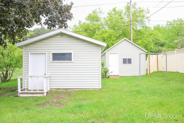 exterior space featuring a yard, fence, and an outbuilding