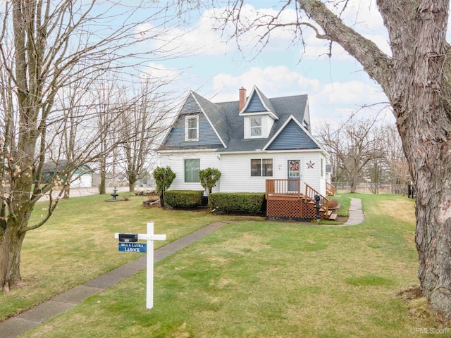 view of front facade with a shingled roof, a chimney, and a front yard