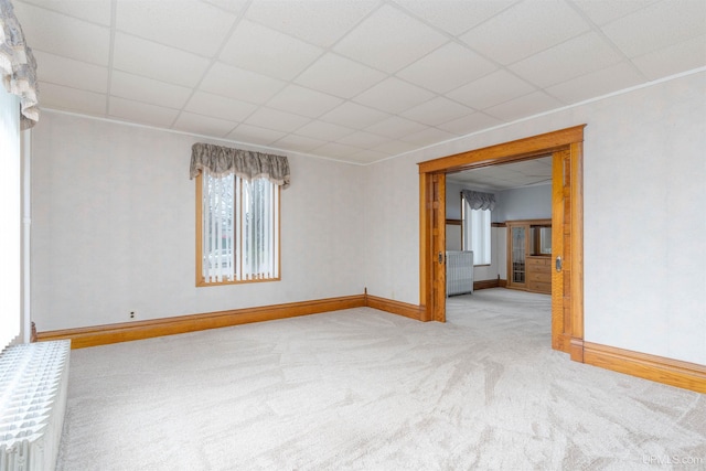 empty room with baseboards, a paneled ceiling, and carpet floors