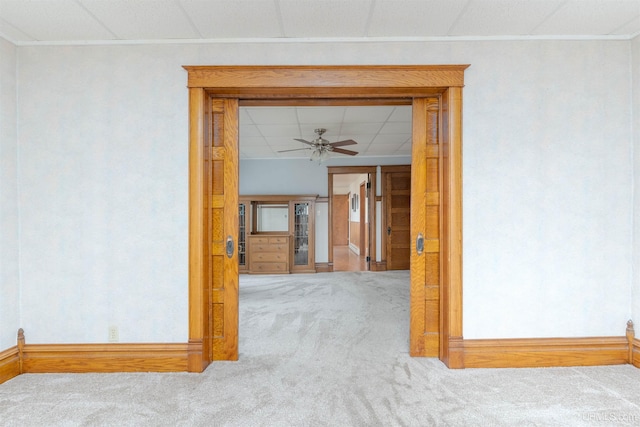 carpeted spare room with baseboards, a ceiling fan, and a paneled ceiling