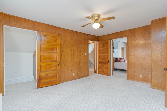 carpeted bedroom with wood walls and a ceiling fan
