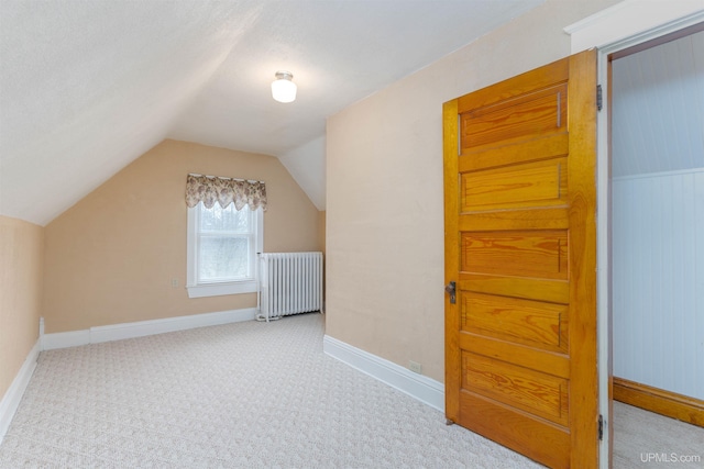 bonus room with baseboards, radiator, carpet flooring, and vaulted ceiling