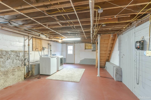 below grade area featuring electric panel, washing machine and dryer, and stairs