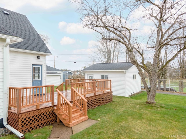 exterior space featuring a yard, a deck, a shingled roof, and fence