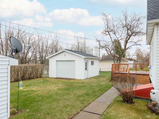 view of yard with a wooden deck, a garage, and an outdoor structure