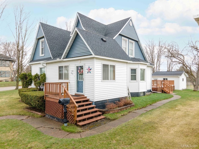 view of front of home with a front yard, roof with shingles, and a wooden deck