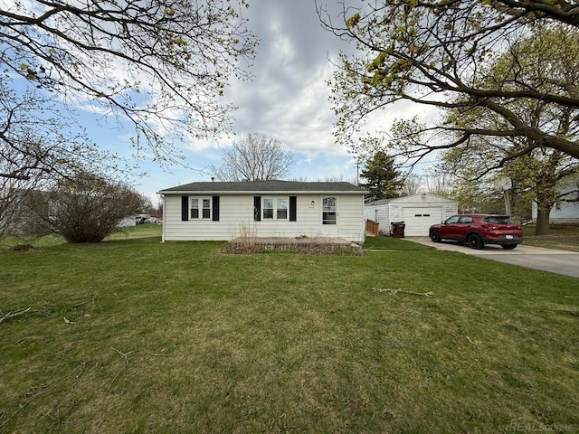 view of front of home featuring concrete driveway, an outbuilding, a front lawn, and a detached garage