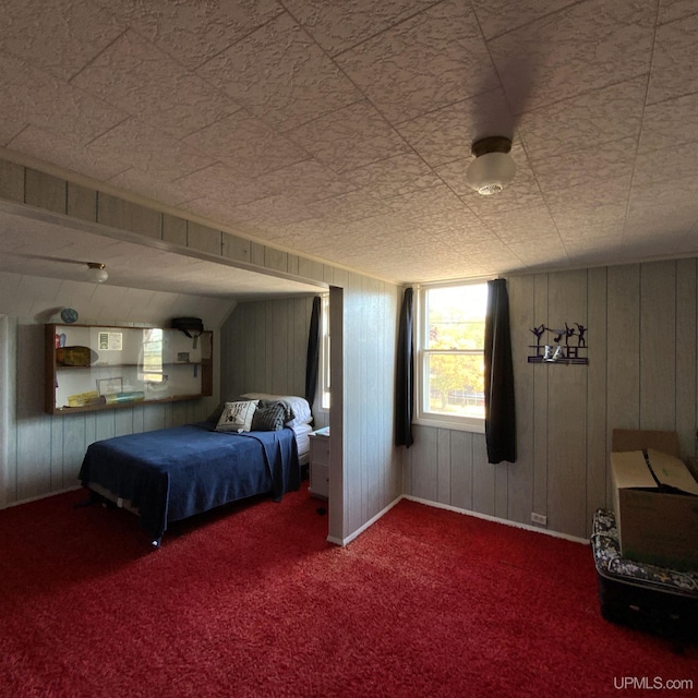 carpeted bedroom with wooden walls and baseboards