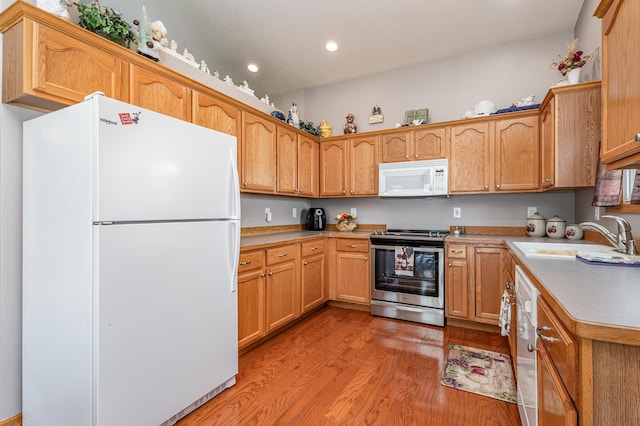 kitchen with light wood-style flooring, recessed lighting, a sink, light countertops, and appliances with stainless steel finishes