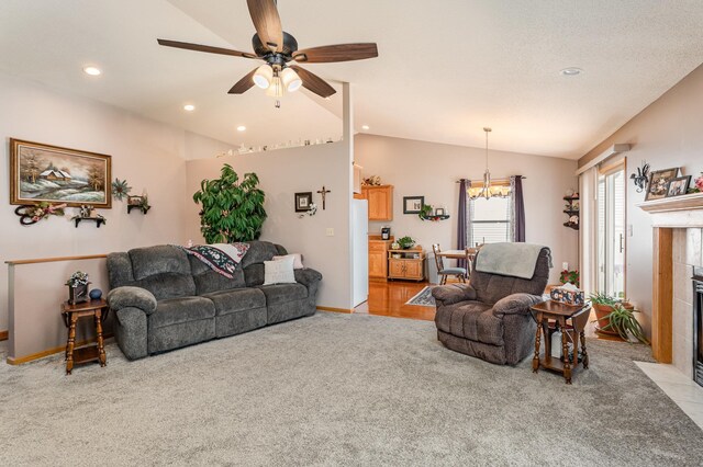 living room featuring lofted ceiling, recessed lighting, ceiling fan with notable chandelier, light carpet, and a fireplace
