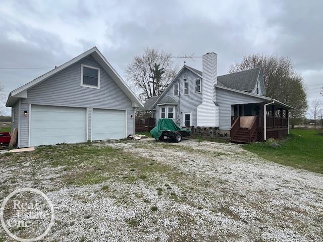view of side of home with a chimney, an outbuilding, and a garage