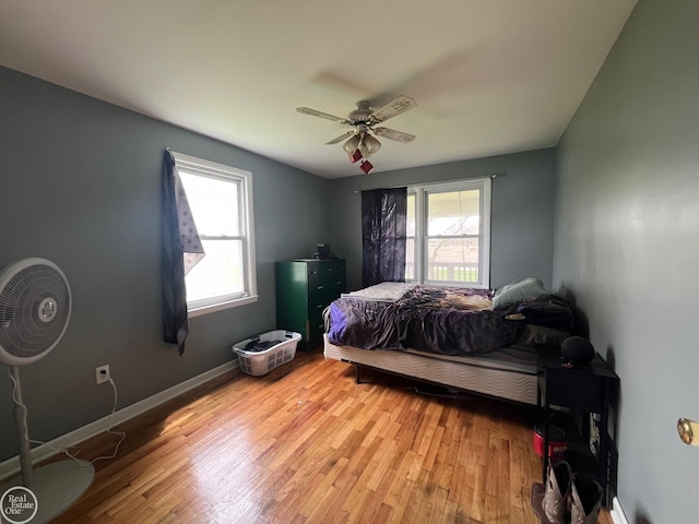 bedroom with light wood-style floors, baseboards, and a ceiling fan