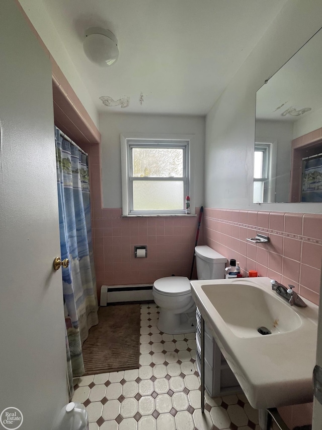 full bath with tile walls, a baseboard radiator, toilet, wainscoting, and tile patterned floors