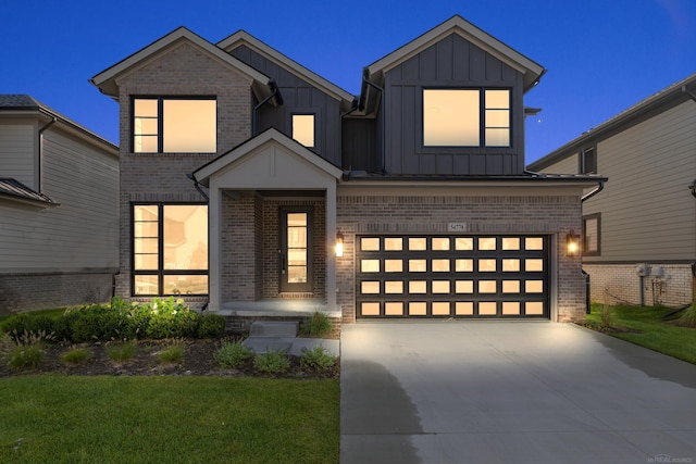 view of front of house with an attached garage, concrete driveway, board and batten siding, a front yard, and brick siding