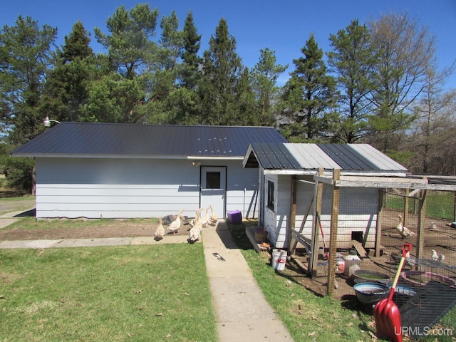 25485 Opal Rd, Watton, MI 49970 - view of front of house with a metal roof, an outdoor structure, a front lawn, and exterior structure