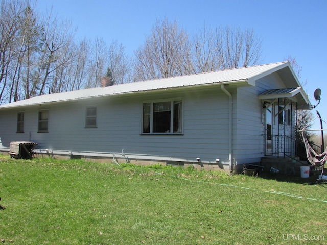 25485 Opal Rd, Watton, MI 49970 - view of property exterior with a chimney, a metal roof, and a lawn