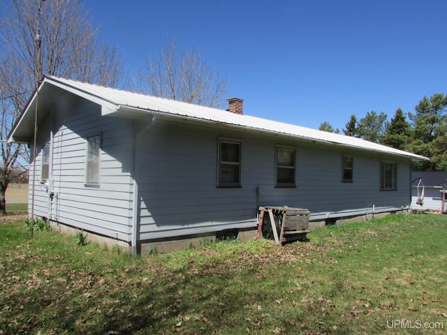 25485 Opal Rd, Watton, MI 49970 - rear view of property featuring a chimney, a metal roof, and a lawn