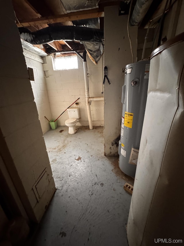 basement featuring water heater and concrete block wall