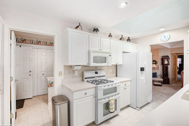 kitchen featuring white appliances, light tile patterned flooring, recessed lighting, light countertops, and white cabinets