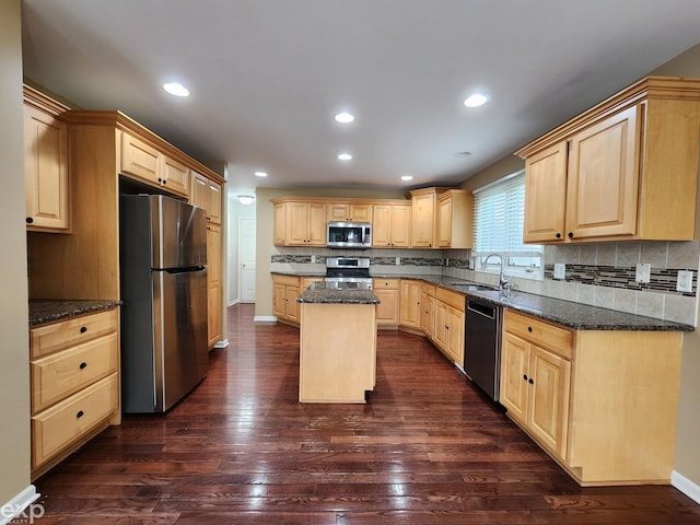 kitchen featuring a sink, dark wood-type flooring, decorative backsplash, light brown cabinets, and appliances with stainless steel finishes