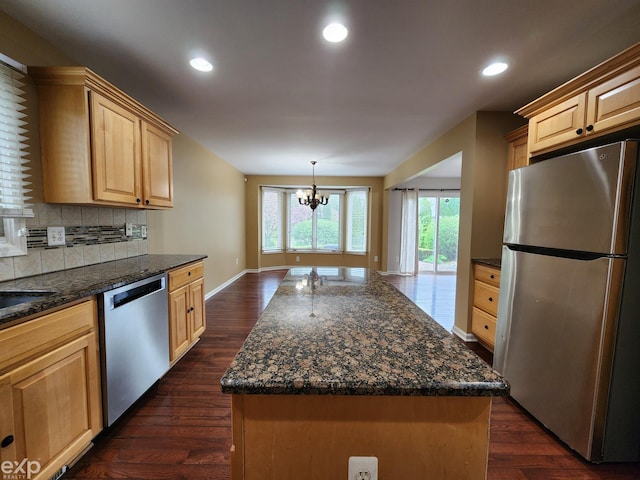kitchen featuring stainless steel appliances, light brown cabinetry, and dark wood finished floors