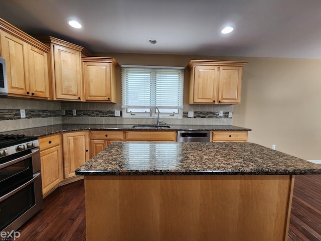 kitchen featuring light brown cabinetry, a sink, backsplash, stainless steel appliances, and dark wood-style floors