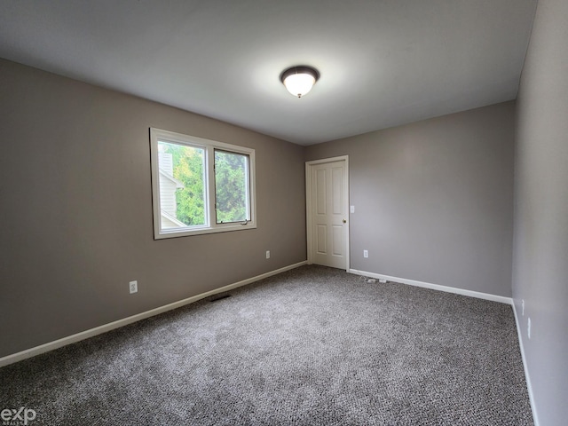 spare room with baseboards and carpet floors