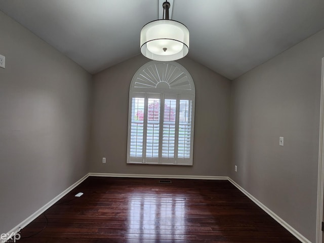 spare room with lofted ceiling, baseboards, and hardwood / wood-style floors