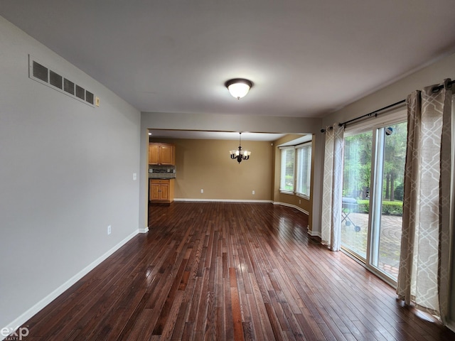 unfurnished dining area with a chandelier, dark wood finished floors, visible vents, and baseboards