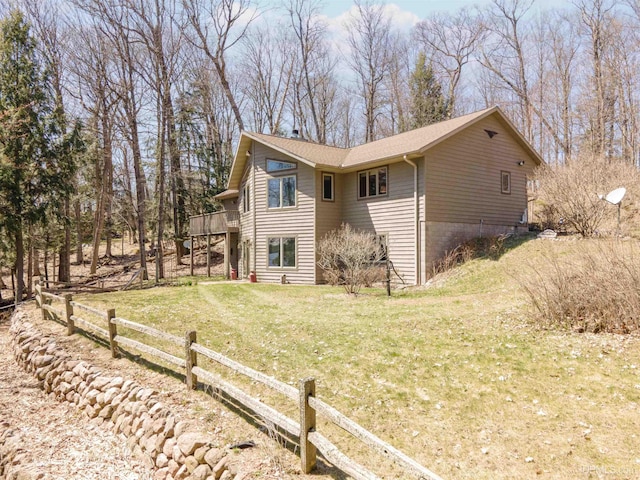view of home's exterior featuring a yard, fence, and a wooden deck