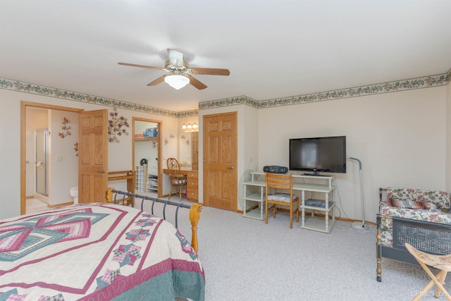 carpeted bedroom with ensuite bathroom and a ceiling fan