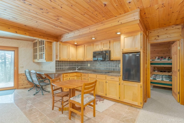 kitchen with a sink, light brown cabinets, black appliances, wooden ceiling, and tasteful backsplash