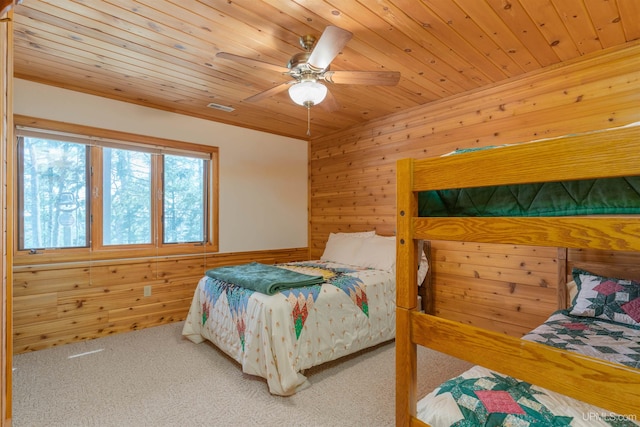 bedroom featuring ceiling fan, wood ceiling, visible vents, wood walls, and carpet floors