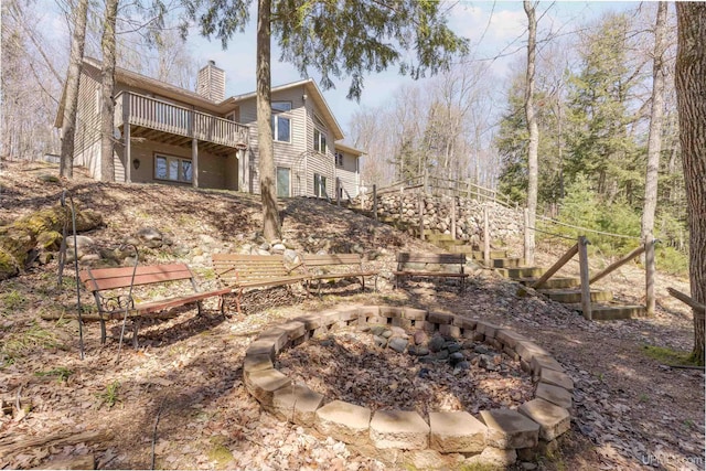 view of yard with stairway, an outdoor fire pit, and a wooden deck