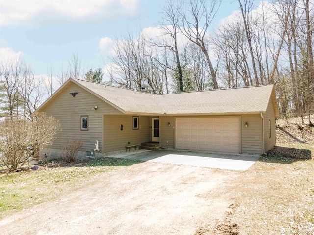 ranch-style home with driveway, roof with shingles, and a garage