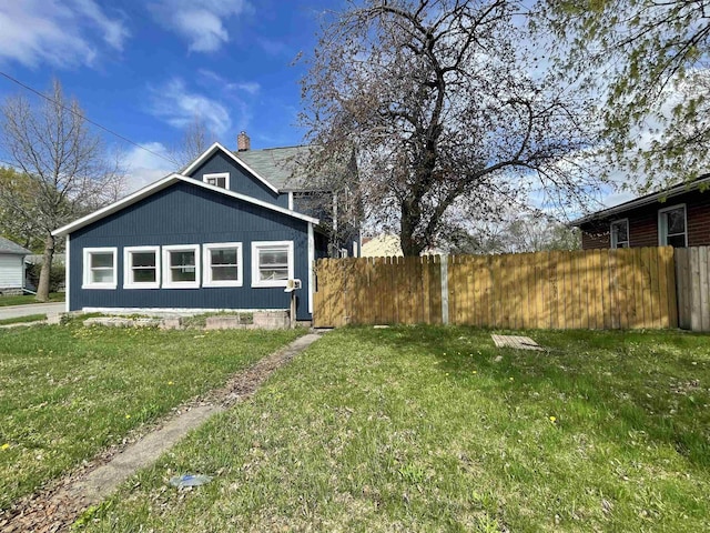 301 Michigan Ave, Bay City, MI 48708 - view of side of property with a yard, a chimney, and fence