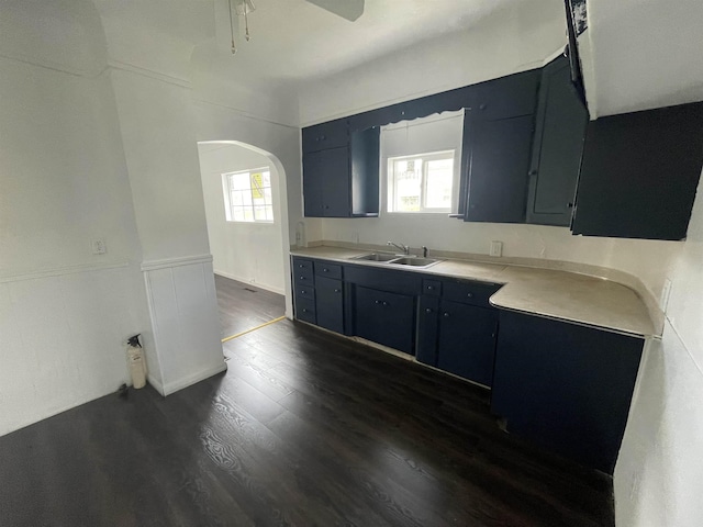 301 Michigan Ave, Bay City, MI 48708 - kitchen with a sink, dark wood-style flooring, wainscoting, arched walkways, and light countertops